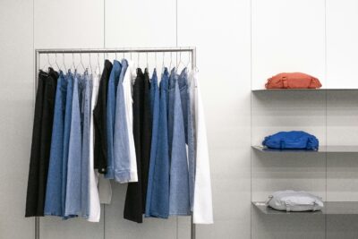 clean capsule wardrobe, clothes stacked, hanged clothes, denim pants, chambray shirts, bags