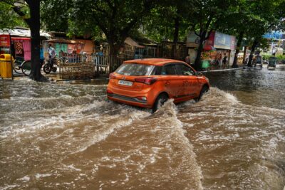 severe rainfall alert preparations, car driving through a flooded street india, car flood in india