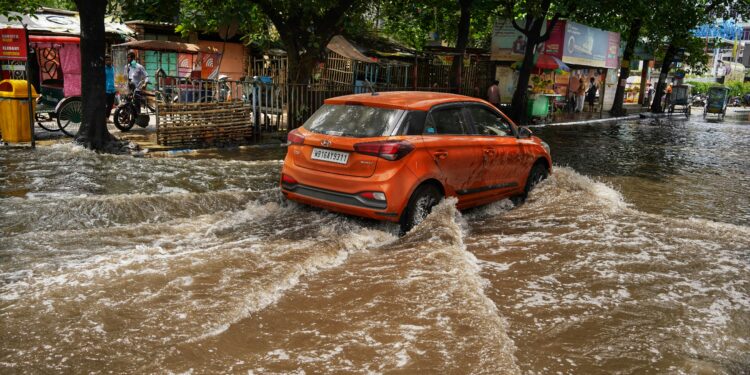 severe rainfall alert preparations, car driving through a flooded street india, car flood in india