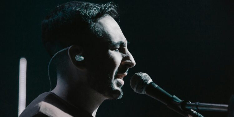 iem earphones, side view of a man singing