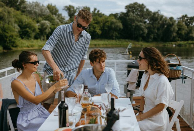 old money fashion aesthetic principles, Man in Blue and White Stripe Button Up Shirt Sitting Beside Woman in White Shirt, friends having brunch
