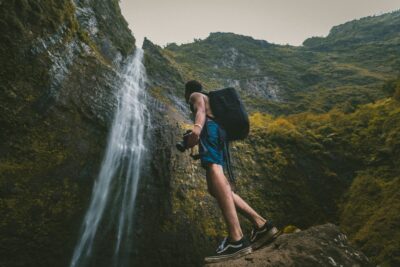 travel photography, backpacker holding a camera, waterfalls, vans old skool canvas sneakers,