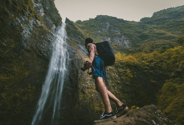 travel photography, backpacker holding a camera, waterfalls, vans old skool canvas sneakers,