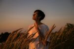 airbuds app - man in sunset field listening to music