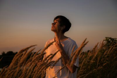 airbuds app - man in sunset field listening to music