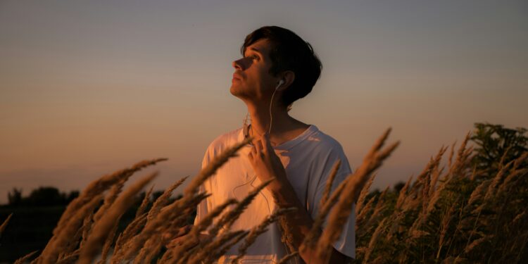 airbuds app - man in sunset field listening to music