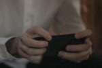 spot fake game ads easily - a man holding a phone