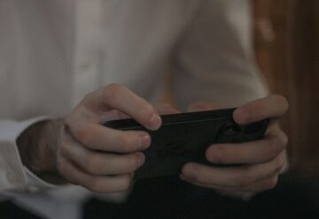 spot fake game ads easily - a man holding a phone