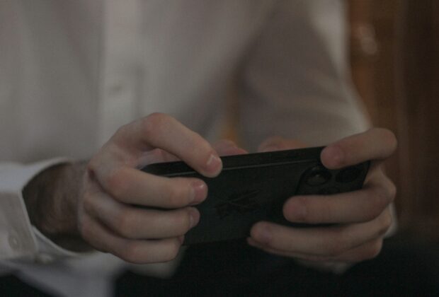 spot fake game ads easily - a man holding a phone