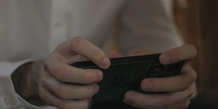 spot fake game ads easily - a man holding a phone