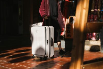 tips to enjoy your holidays when bored - woman walking with white luggage