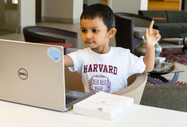 digital literacy in classrooms - child holding hand up in front of laptop