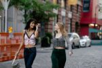 Two Teenage Girls in Trendy Y2K Fashion Clothing Walking in the City