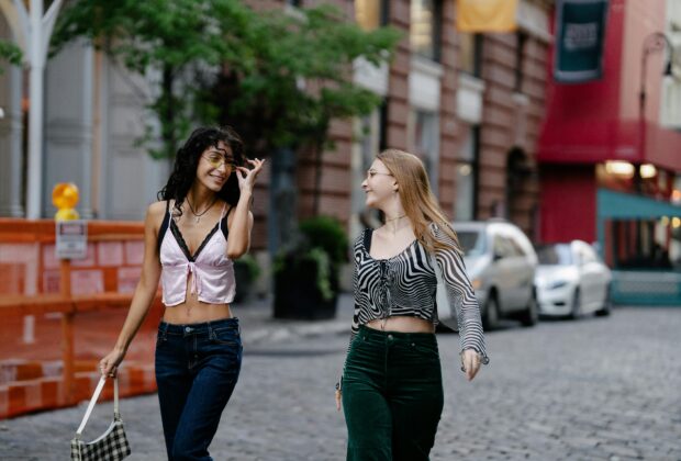 Two Teenage Girls in Trendy Y2K Fashion Clothing Walking in the City