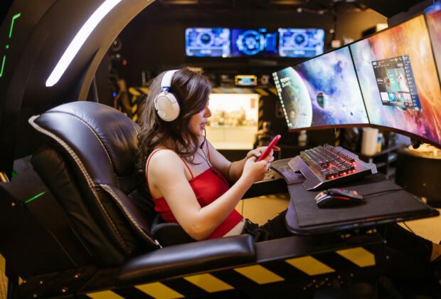 Woman Using Her Smartphone while Playing League of Legends Group Games