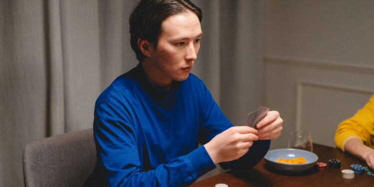 poker shark photo of a man in a blue sweatshirt playing poker