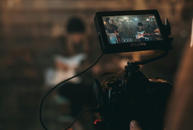 unknown person playing guitar in front of a live stream camera