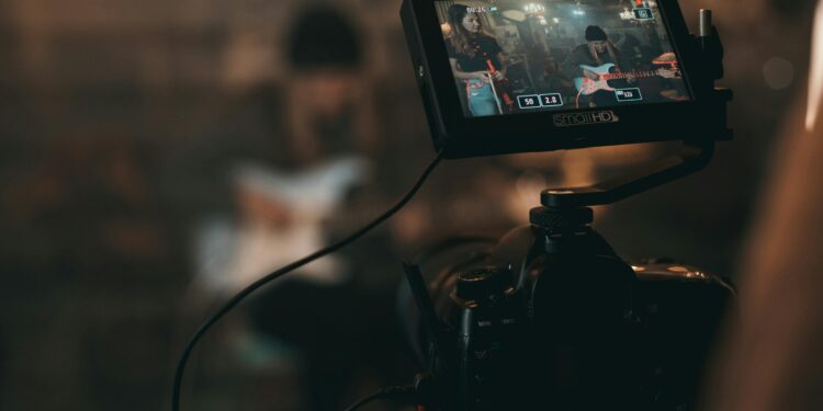 unknown person playing guitar in front of a live stream camera