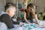 woman in gray long sleeve shirt sitting beside boy in gray long sleeve shirt, gamification in education