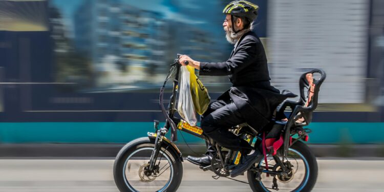 side view of a man riding an electric cycle bike