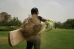indian cricket player stricking a ball covered in mud