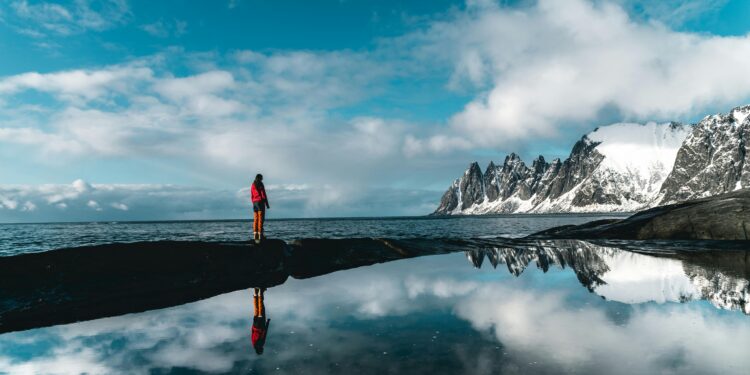person standing near a body of water creating inspiration for travel quotes
