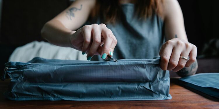 Woman zipping a bag from a set of packing cubes