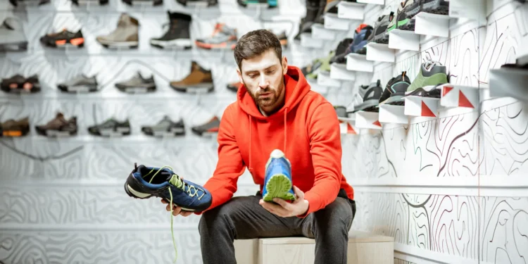man sitting and shopping for sports shoes for men