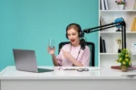 woman in front of laptop and mic holding a glass of water and recording one of the best podcasts for motivation